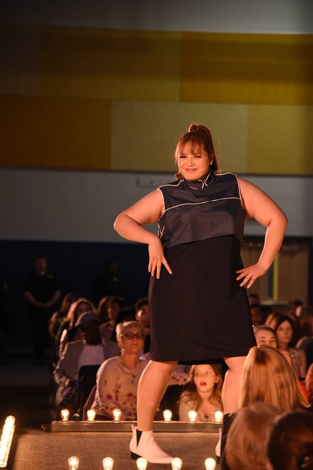 Female student posing in black dress.