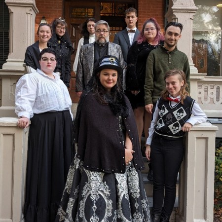 portrait of students and professor in period costume on the stairs of the Morgan Manning House