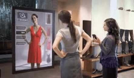 photo of shopper viewing a monitor and looking at a dress as it would look on her